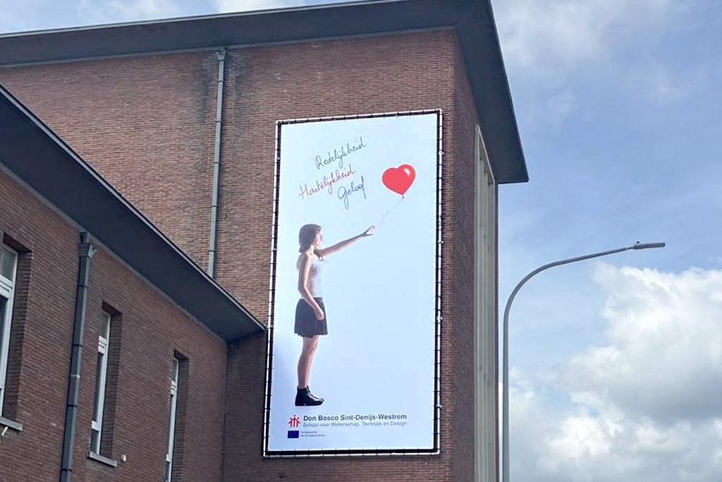 Banner van het kunstproject aan de straatzijde van de school